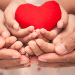Red heart in child kid  mother and father hands in vintage color tone. love,care and family concept